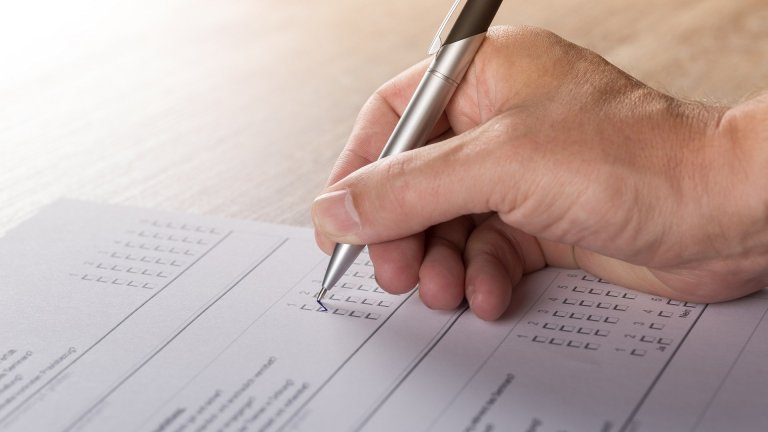 Hand mit Stift schreibt auf einem Blatt Papier