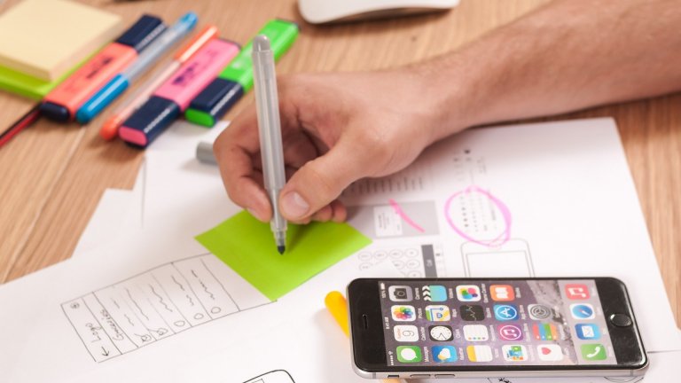 UX Designer, der sich mit der Planung mobiler Applikationsprojekte mit klebrigen Notizen beschäftigt. User Experience concept.
