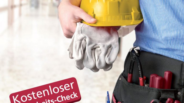 Handwerker mit Helm und Handschuh in der Hand und Werkzeuggürtel