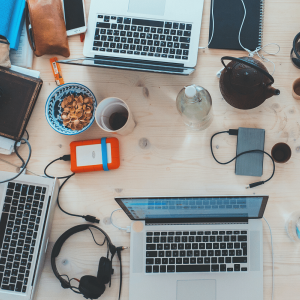 Blick auf einen Tisch an dem mehrere Personen mit Laptop arbeiten